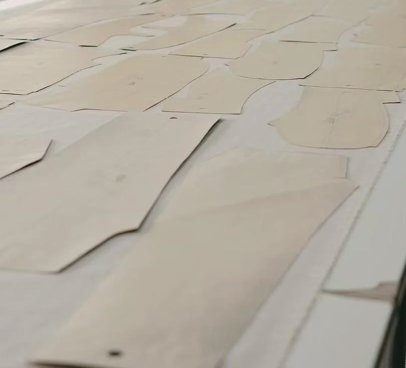Paper garment patterns spread across a cutting table.