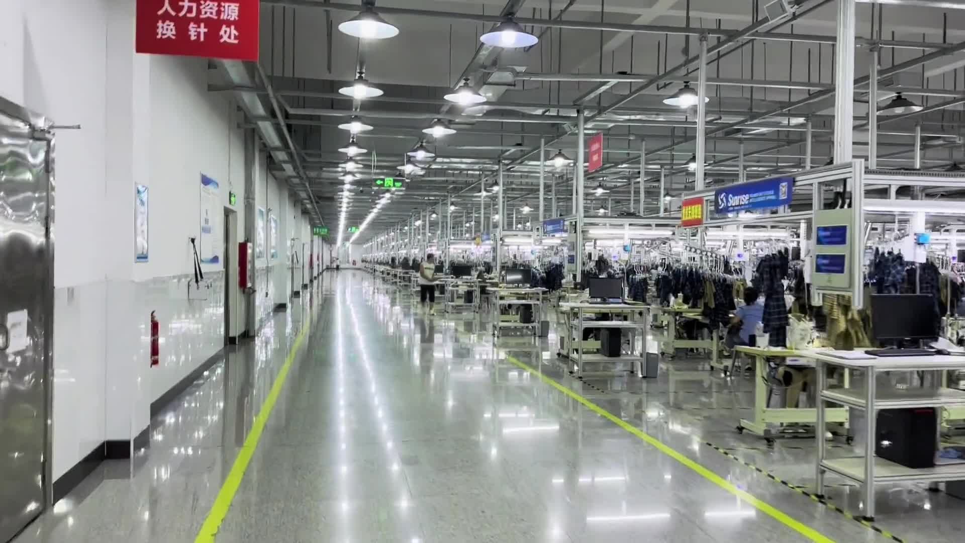 A production aisle lined with garment workstations and overhead equipment.
