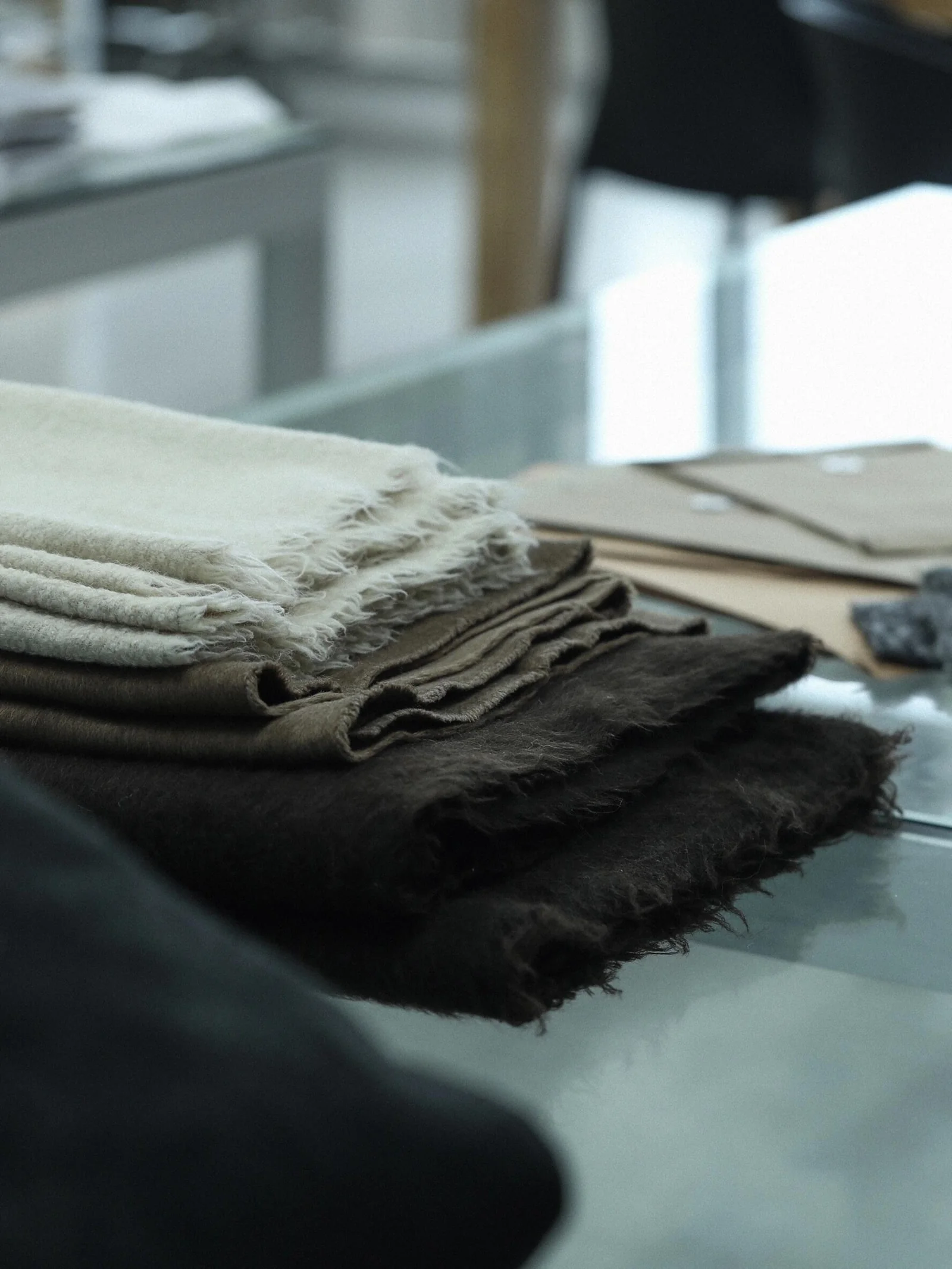 Layered fabric swatches arranged on a work table.