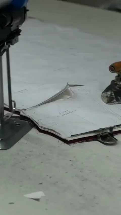 Fabric cutting machine and operator’s hands.