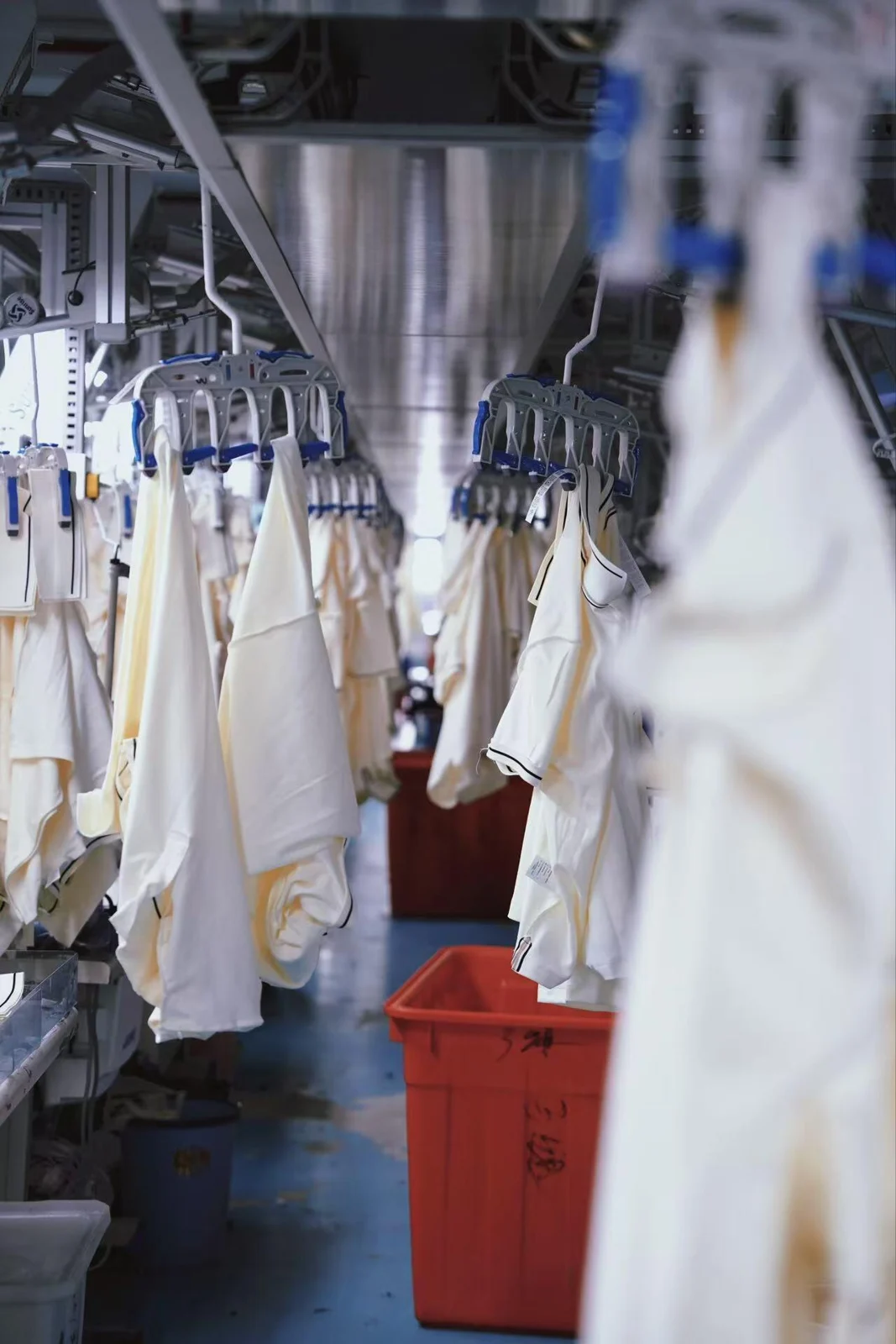 Garments on an overhead workshop rail.